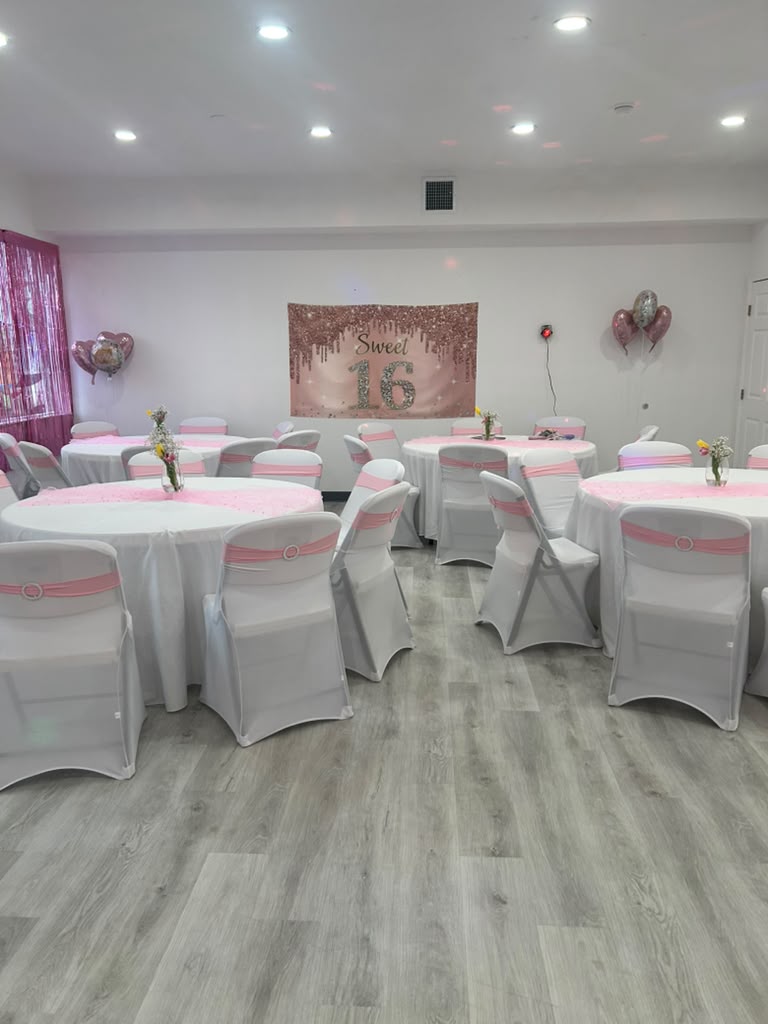 Studio set up for a Sweet 16 celebration with round tables and pink decor